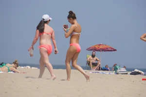 Two sexy girls in peach and pink bikinis on the beach