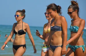 Foursome bikini friends walking the beach