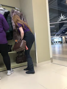 Cute candid shop assistant wearing boots and tight pants