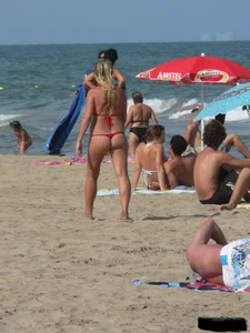 Sexy mom and daughter in red thongs at the beach