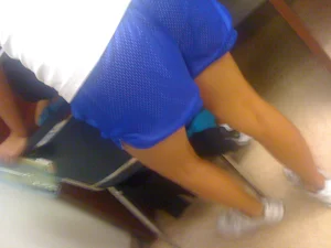 Booty in Blue Shorts And Skinny Legs in White Sneakers Closeup