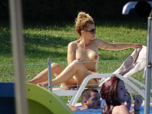 Topless lady at the pool with nice tits