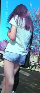 Skinny girl with purple hair in denim shorts