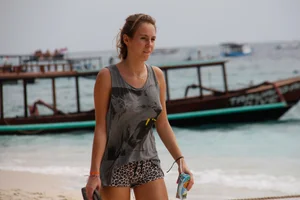 Braless girl in a tanktop walking the beach with her pokies out