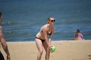 Chunky blonde in a black bikini on the beach