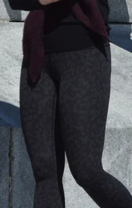 Brunette with glasses on the phone in tight patterned leggings