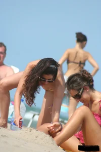 2 topless girls at the beach in thongs