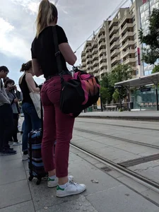 Hot teen booty in tight red pants on a tram stop street creepshot