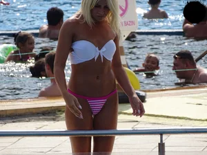 Tanned blonde looking sexy at the pool in thong