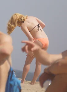 Hot blonde in peach and black bikini on the beach