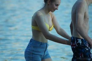 Hot Girl in Swimsuit Top and Denim Shorts by the Water on the Beach Creepshots
