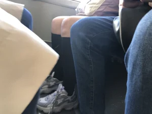 A Very Cute And Skinny Candid Teen Girl Wearing Glasses, A Skirt And Knee Socks Sitting in a Public Bus, Closeups of Her Legs
