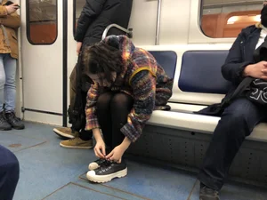 Cute Teen in Black Pantyhose And Sneakers Tying Her Shoelaces in a Subway Train