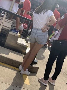 Bunch of girls in various outfits at a Cardinals baseball game
