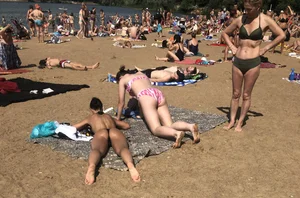 Gorgeous milf rubbing sun lotion in her skin at the beach, with a couple of her milf friends
