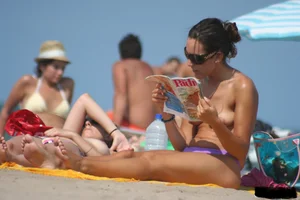 2 topless girls at the beach in thongs