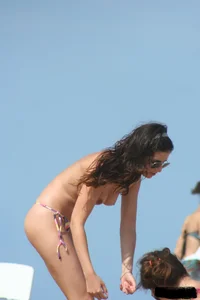 2 topless girls at the beach in thongs