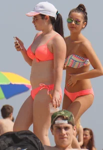 Two sexy girls in peach and pink bikinis on the beach
