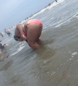 Thick beach girl with big boobs in a peach bikini