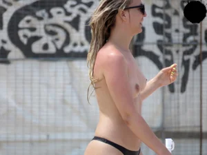 Topless blonde babe on the beach with a big booty in a black thong