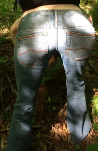 Slim girl in skinny jeans bending over, closeup of her booty