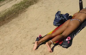 Sexy girl getting some sun laying on the beach in thong bikini
