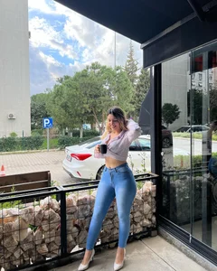 Nice girl in a top and tight blue jeans with wide hips and long stocky legs