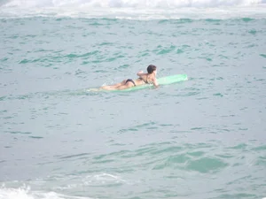 Mature short haired brunette surfer looking sexy on the beach