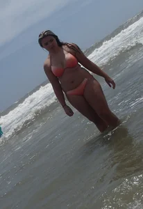Thick beach girl with big boobs in a peach bikini