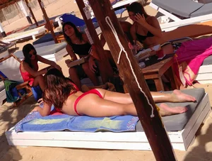 Thick brunette on the beach with friends in red bikini