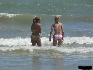 Sexy blonde on the beach in a yellow thong bikini