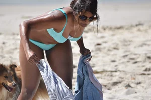 Tanned brunette girl on the beach in a bikini