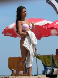 Hot brunette ethnic girl on the beach in a pink thong bikini