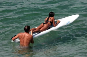 Black girl on the beach in a bikini with an incredible ass while surfing
