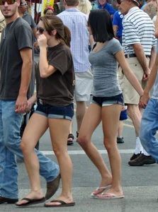 Skinny brunette in tiny denim shorts showing a little cheek