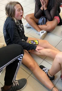 Teens in shorts sitting on the floor