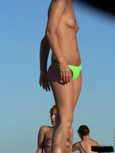Bunch of sexy babes on the beach topless and in thong bikinis