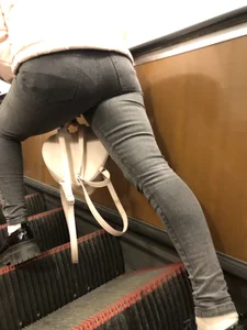 Nice ass in tight grey jeans, candid girl standing on the subway escalator spreading her legs real wide