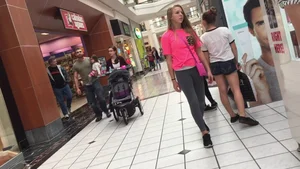 Little blonde teen in grey leggings at the mall with her friends