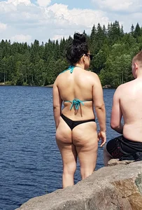 Thick brunette at the lake in a black thong bikini