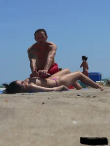 Purple thong topless lady on the beach gets oiled up by her husband