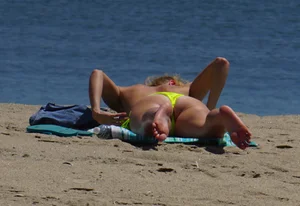 Sexy ass blonde milf on the beach in a thong with cameltoe and bending over
