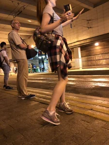 Cute Teen in Shorts on the Tram Stop