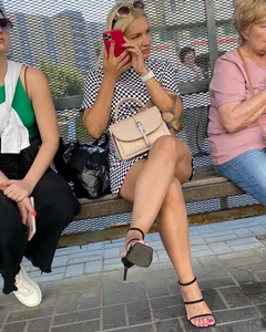 Candid hot blonde milf wearing high heels and red nail polish while showing sexy legs in short dress
