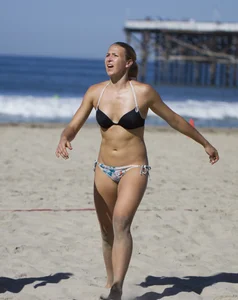 Hot girls playing beach volleyball in bikinis and shorts