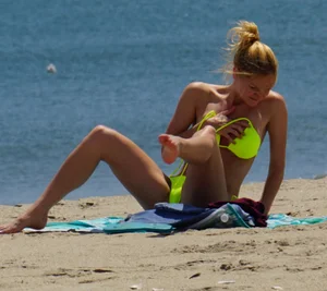 Sexy ass blonde milf on the beach in a thong with cameltoe and bending over