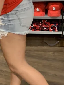 Bunch of girls in various outfits at a Cardinals baseball game