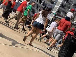 Bunch of girls in various outfits at a Cardinals baseball game