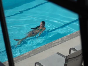 Hot milf sunbathing in a thong by pool and swimming