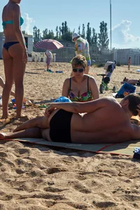 Sexy blonde milf on the beach in blue thong bikini and showing nice camel toe